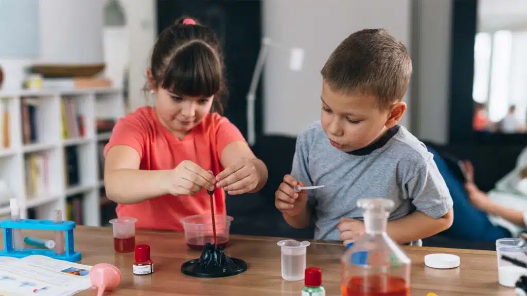 Two children engaging in a hands-on science experiment at a table
