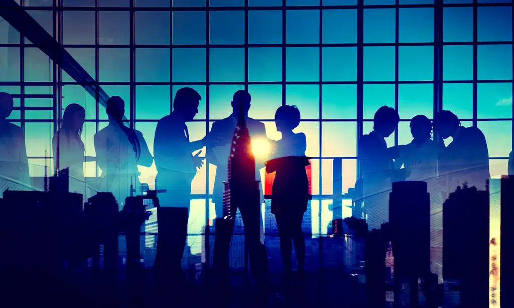 Silhouettes of business professionals engaged in discussions inside a modern office