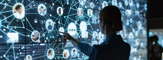 A woman indicates a large screen showcasing numerous social media icons, depicting a detailed relationship map.