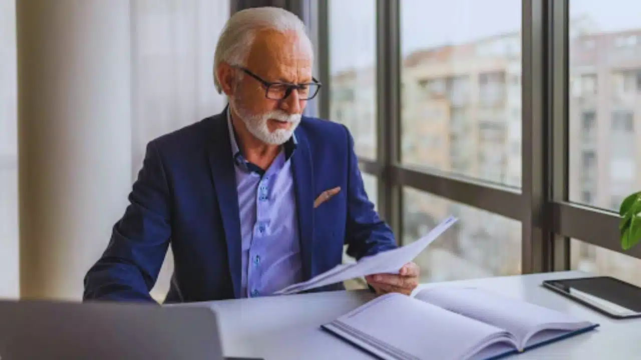 A man in a suit looking at a laptop and wondering, “What documents do I need to change my address in Michigan?
