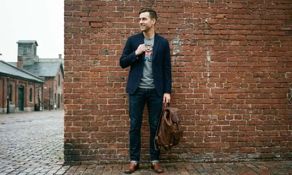 A fashionable man modeling a blazer over a gaming t-shirt in an urban Toronto setting