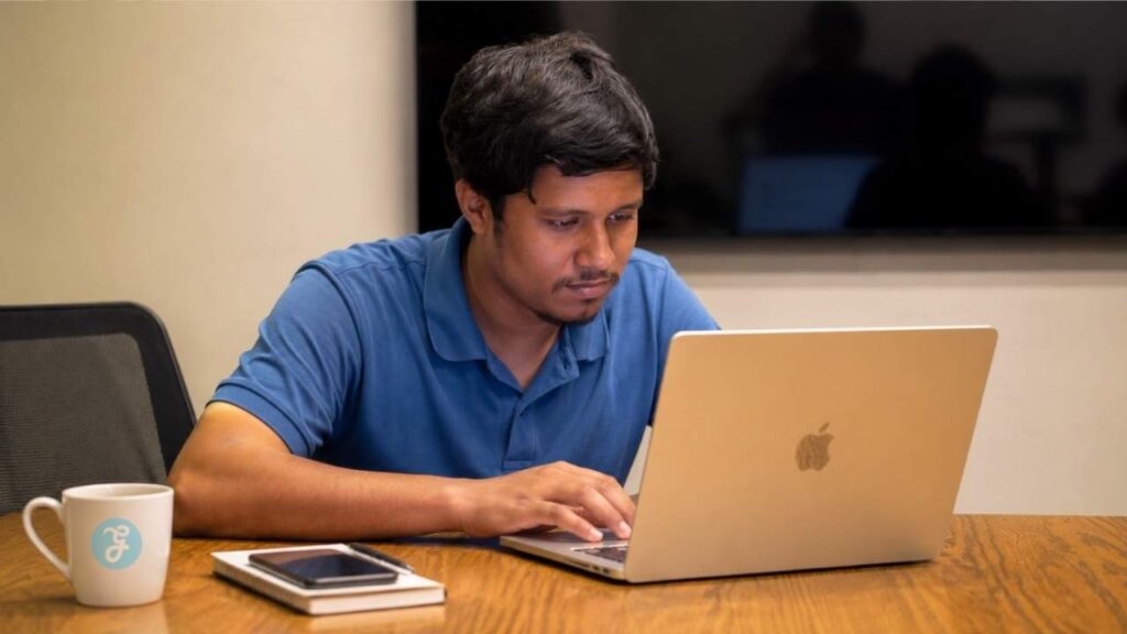 Professional working on an Apple laptop while exploring computer vision and how it works through practical AI applications.